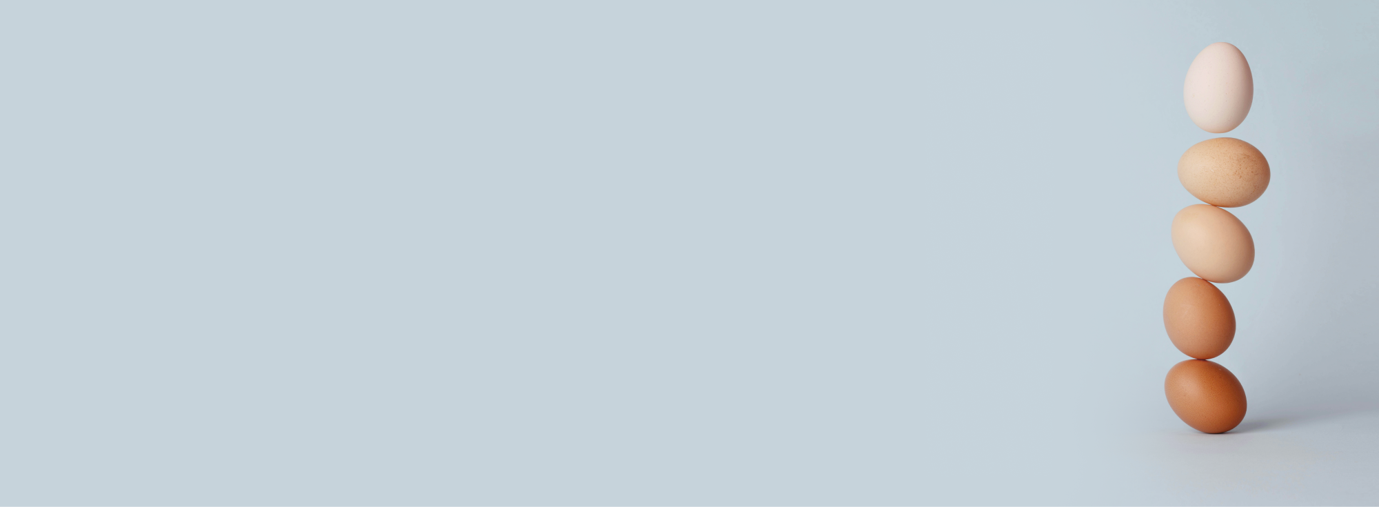 gestapelte Eier auf blauem Hintergrund