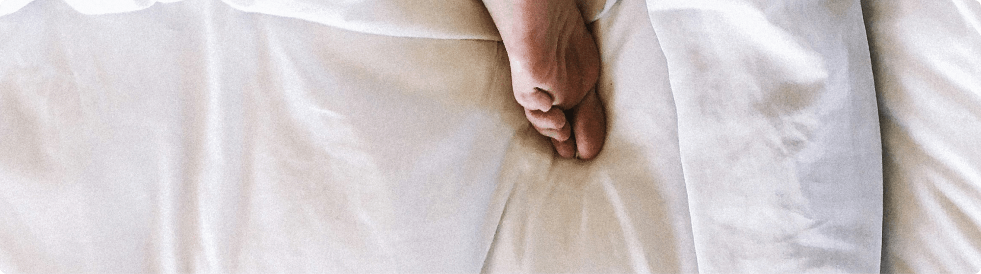 Fuß einer schlafenden Person im Bett