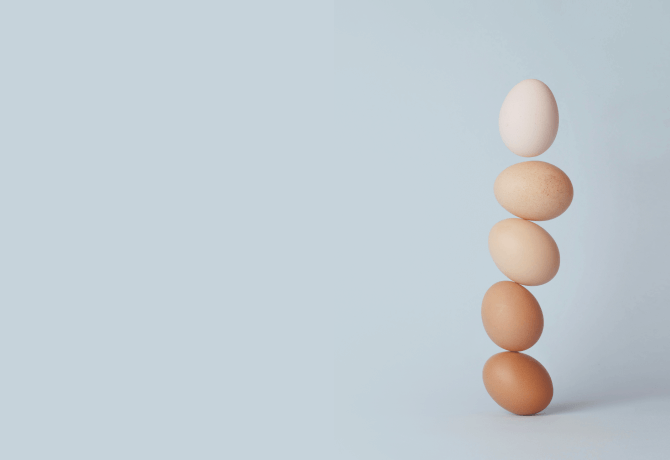 gestapelte Eier auf blauem Hintergrund