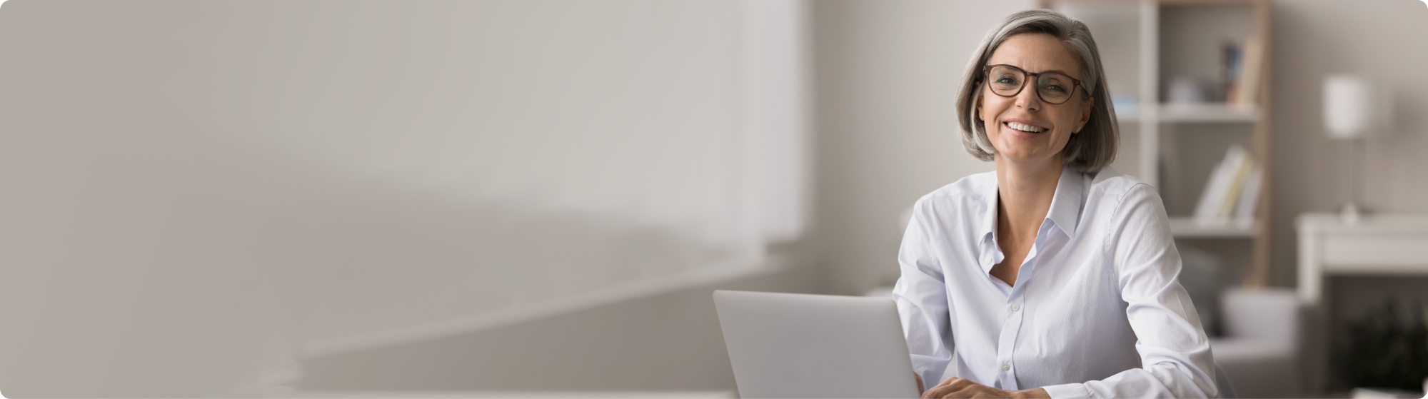 Frau mittleren Alters am Laptop lächelt