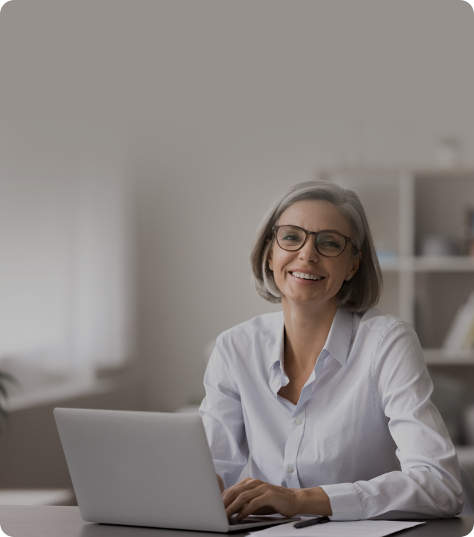Frau mittleren Alters am Laptop lächelt